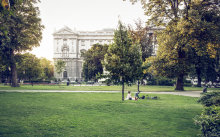 A couple is relaxing in the grass at the park in front of the Hofburg.