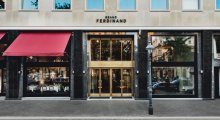 The entrance of Grand Ferdinand hotel is a golden portal.