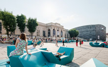 People relaxing on turquoise seats at the MuseumsQuatier square.