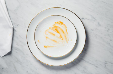 Finished dessert on a porcelain plate with golden rim.