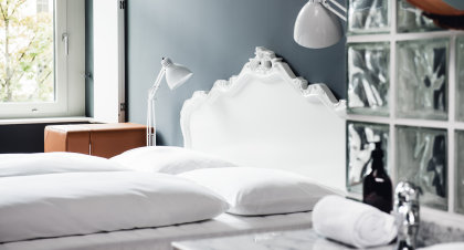 Standard Zimmer mit weißem Kingsize-Bett und dezenten Dekoelementen.