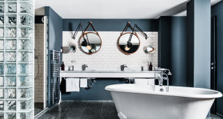 Grand Ferdinand Suite mit zwei Waschbecken, Spiegeln mit Lederrahmen und freistehender Badewanne.